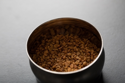 Spice tin of fenugreek seeds - Australian Stock Image