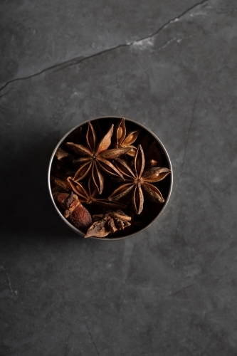 spice tin of star anise on dark marble background - Australian Stock Image