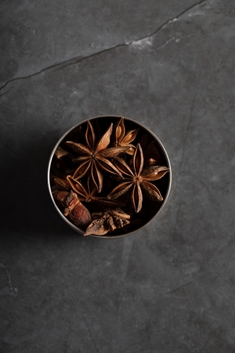 spice tin of star anise on dark marble background