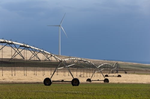 Sprayer on paddock with crops with wind turbine in background - Australian Stock Image