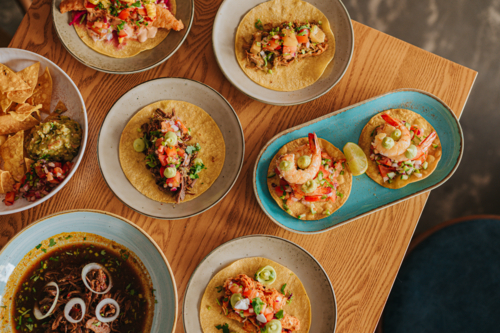 Spread of Authentic Mexican Tacos and Snacks on a Wooden Table - Australian Stock Image