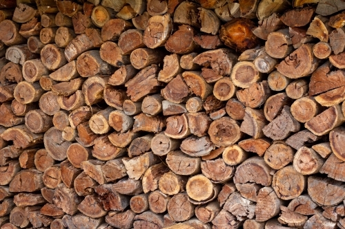 stack of logs against wall - Australian Stock Image