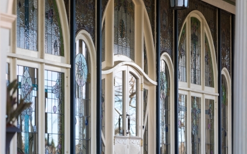 Stained glass facade with reflected natural light from exterior perspective