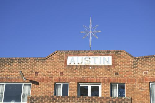 Star and Austin sign on top of old brick unit block - Australian Stock Image