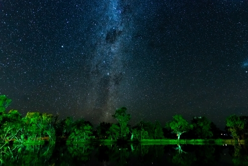 Starry night sky with Milky Way and reflections of trees in a lagoon - Australian Stock Image