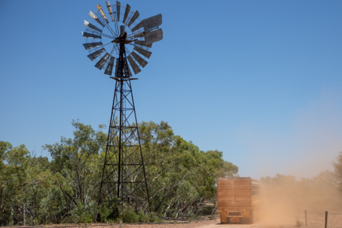 Station truck passing a windmill - Australian Stock Image
