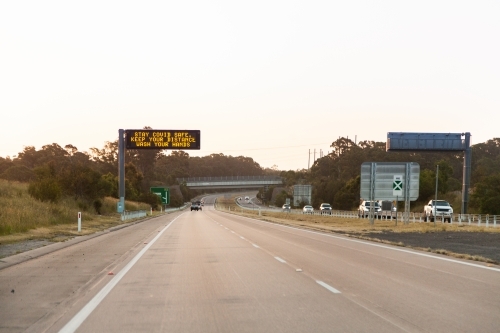 Stay covid safe, keep your distance, wash your hands sign above highway - Australian Stock Image