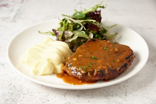 Steak with mash potato, gravy and green salad - Australian Stock Image