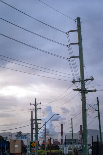Steel Smelter behind power lines and poles - Australian Stock Image