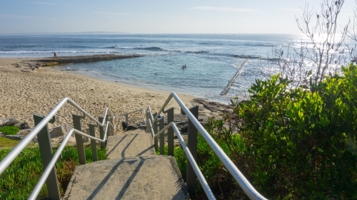 Steps and handrails leading down to beach and Oak Park ocean pool - Australian Stock Image