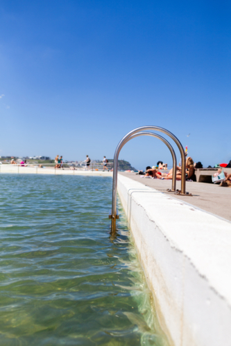 steps into ocean pool in on Merewether beach baths in Newcastle on sunlit summer day - Australian Stock Image