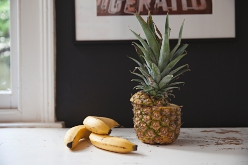Still life table top in kitchen with bananas and pineapple - Australian Stock Image