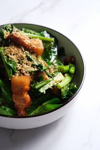 Stir-fried green leafy vegetable with pork belly slices garnished with crushed peanuts. - Australian Stock Image
