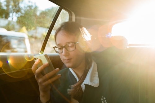 teen in school uniform, being driven to school in the morning - Australian Stock Image