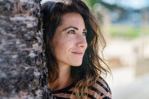 stock photo of woman behind tree - Australian Stock Image