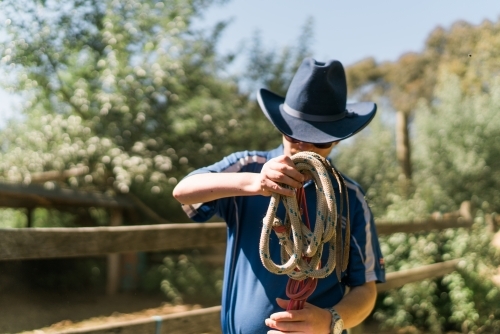 Stockman with Blue Hat Winding a Rope