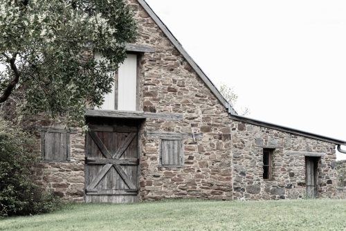 stone barn with wooden doors and shutters