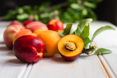 stone fruits on a wooden white background - Australian Stock Image