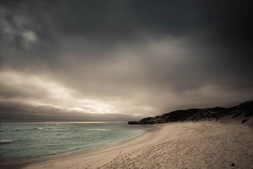 Storm clouds gathering over a pristine beach