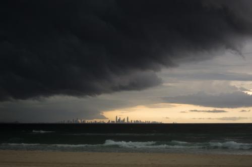 Storm clouds over sea with Gold Coast building in the distance - Australian Stock Image