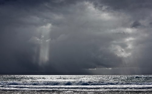 Storm over ocean, casting light, silver sea, moody