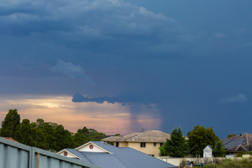 storm rolling in over suburbs with dark rain clouds in the sky - Australian Stock Image