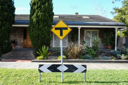 Street signs out the front of a residence in the suburbs