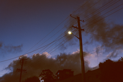 Streetlight glowing against dusky sky - Australian Stock Image
