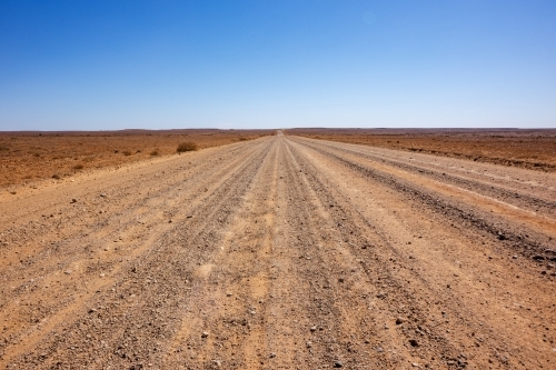 stretch of dirt road in desert landscape - Australian Stock Image