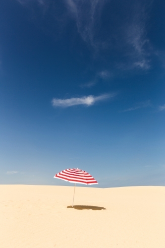 Stripy umbrella on a beach - Australian Stock Image