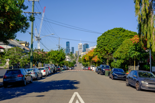 Suburban Street with Keep Left Sign and Brisbane CBD in the Background - Australian Stock Image