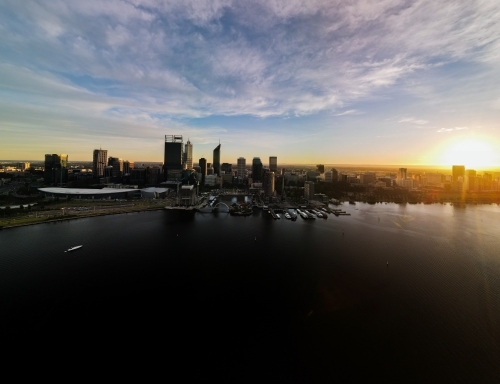 Sun almost set behind Swan River and Perth city skyline - Australian Stock Image