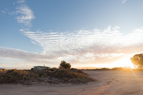 Sun lowering down on the horizon emitting a soft glow. - Australian Stock Image