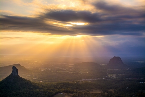 Sun rays coming through the clouds high up in the glass house mountains