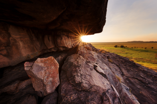 Sun sets through the ancient stone country in Kakadu, on the edge of the Arnhem Land escarpment - Australian Stock Image