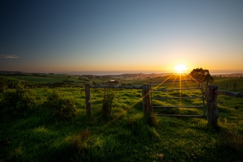 Sun setting behind a coastal farm - Australian Stock Image
