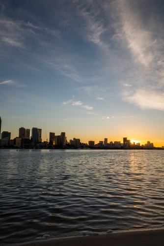 Sun setting behind Swan River and Perth city skyline - Australian Stock Image