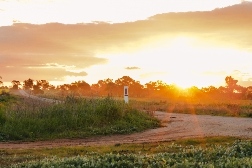 Sun setting on country road in Central Victoria, Australia - Australian Stock Image