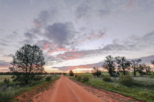 Sun setting on dirt country road in Central Victoria - Australian Stock Image