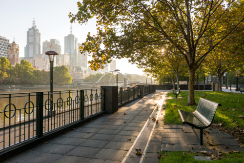 Sunlight filtering through trees along quiet riverside walkway in central Melbourne. - Australian Stock Image