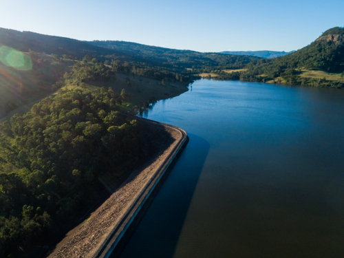 sunlight over Glennies creek dam wall water supply seen from aerial view in Hunter Valley - Australian Stock Image