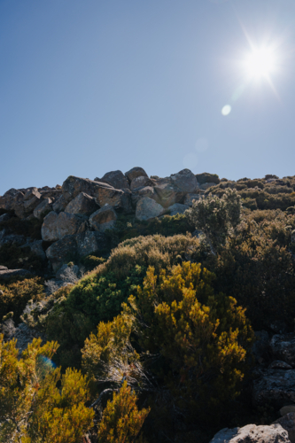 sunlight over mountain with rugged rock terrain in wilderness - Australian Stock Image