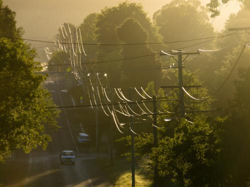 Sunlight reflected off power lines in a suburban street - Australian Stock Image
