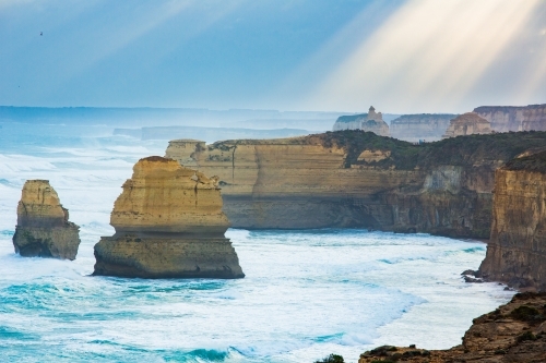Sunlight streaming on Twelve Apostles Sea Stacks - Australian Stock Image
