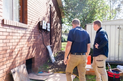 sunlit electricians installing solar power to house - Australian Stock Image