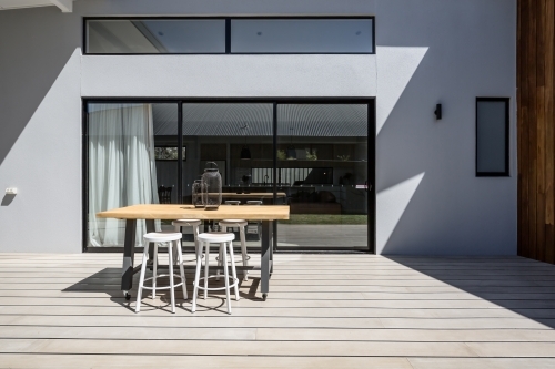 Sunny outdoor entertaining deck with triple glass sliding doors - Australian Stock Image