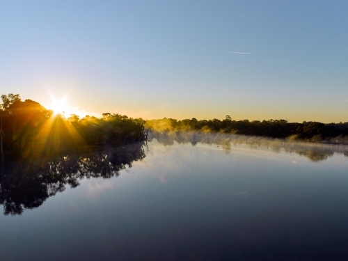 Sunrise and mist on a river in the country - Australian Stock Image