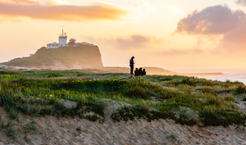 Sunrise at Nobby's Beach with Nobby's Lighthouse in the Background and a Family in the Midground - Australian Stock Image