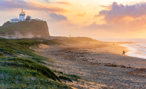 Sunrise at Nobby's Beach with Nobby's Lighthouse in the Background Newcastle New South Wales - Australian Stock Image