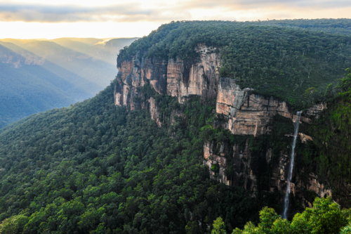 Sunrise from Govetts Leap lookout in the Blue Mountains overlooking a fog filled valley with cliffs - Australian Stock Image